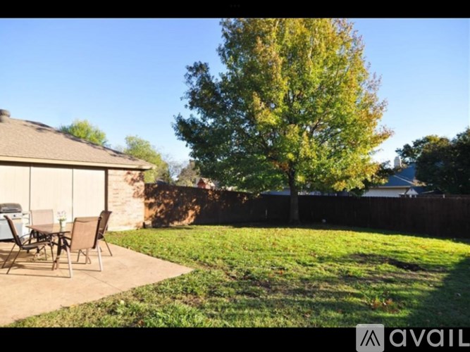 A backyard with a patio table and chairs.