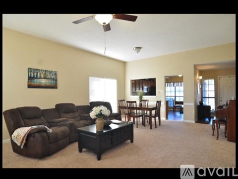 A living room with a brown leather sofa and a coffee table.