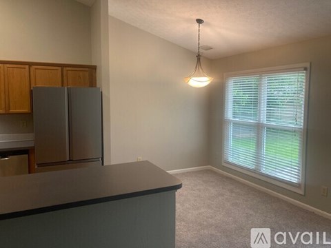 A kitchen with a refrigerator and cabinets.
