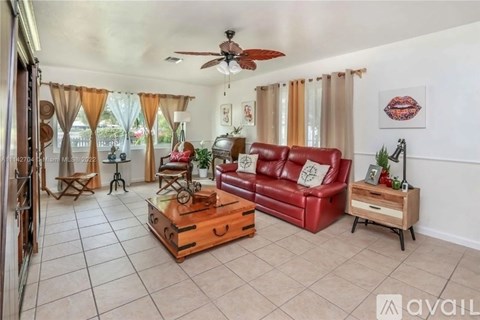 A living room with a red couch and a ceiling fan.