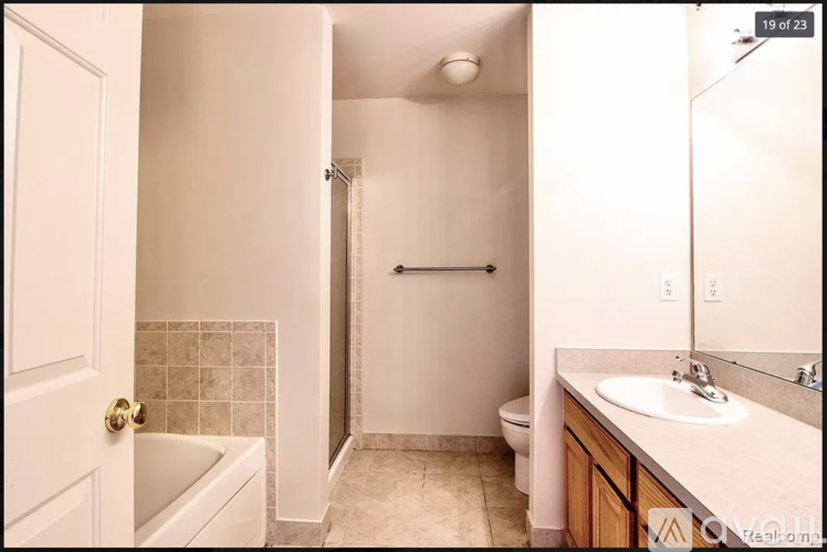 A white bathroom with a toilet, sink, and bathtub.