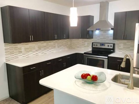 A kitchen with black cabinets and a white countertop.