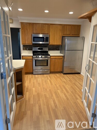 A kitchen with wooden cabinets and a refrigerator.