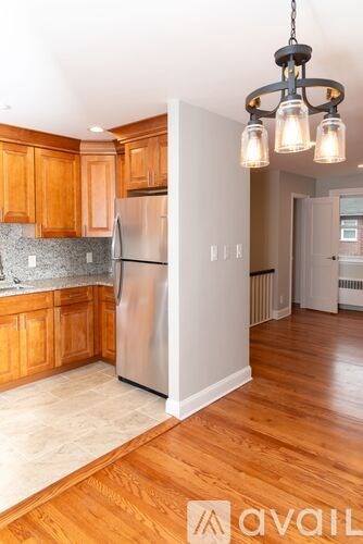 A kitchen with wooden cabinets and a silver refrigerator.