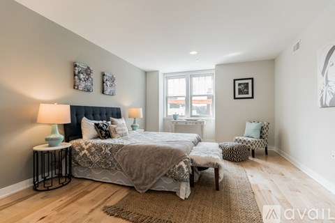 A bedroom with a large bed and a chair.