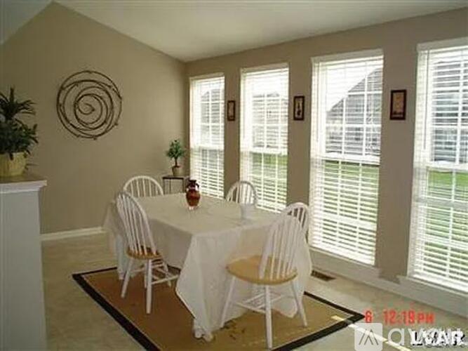 A dining room with a table set for four.