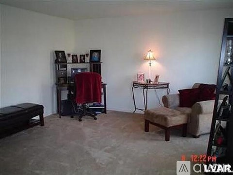 A living room with a red chair and a lamp.
