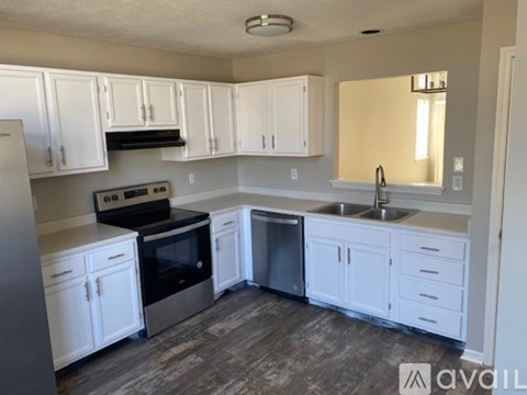 A kitchen with white cabinets and a stove top oven.