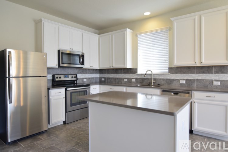 A kitchen with a stainless steel refrigerator, microwave, oven, and cabinets.