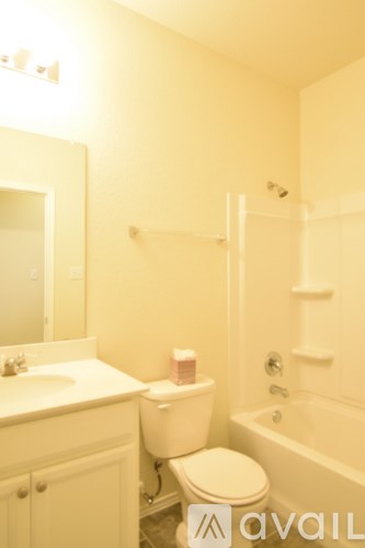 A white bathroom with a toilet, sink, and bathtub.