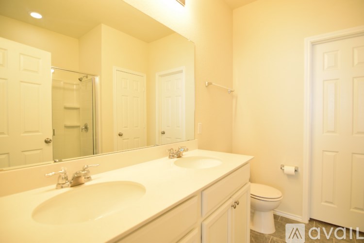 A bathroom with a white sink and toilet.