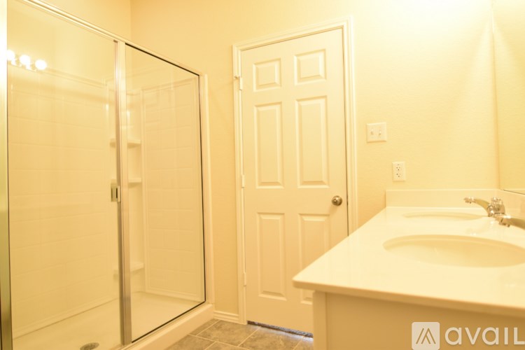 A bathroom with a sink, mirror, and shower.