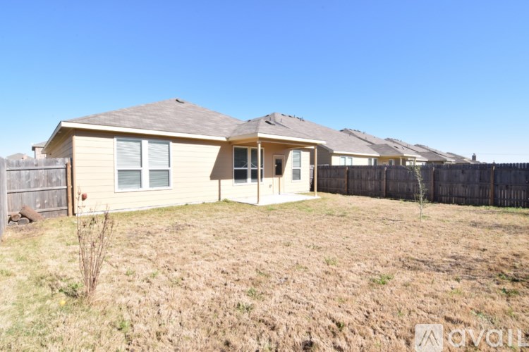 A house with a brown roof and a brown fence in the front yard.