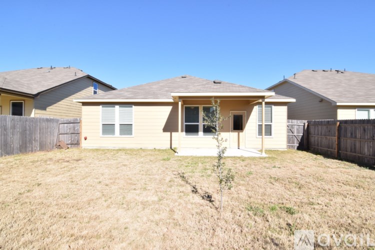 A house with a brown roof and a fence in the front yard.