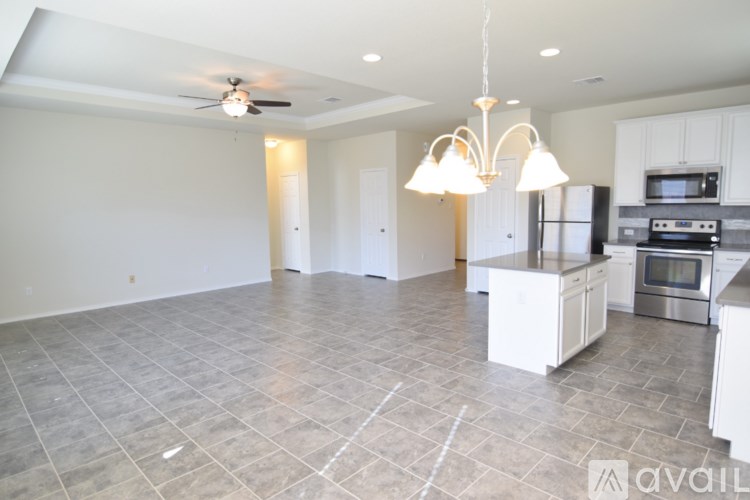 A kitchen with a refrigerator, microwave, and oven is available for rent.