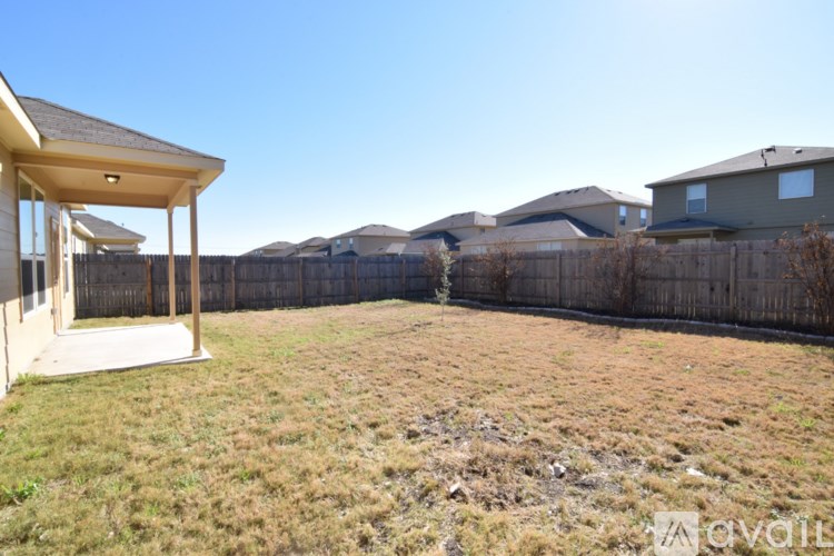 A backyard with a wooden fence and a small house.
