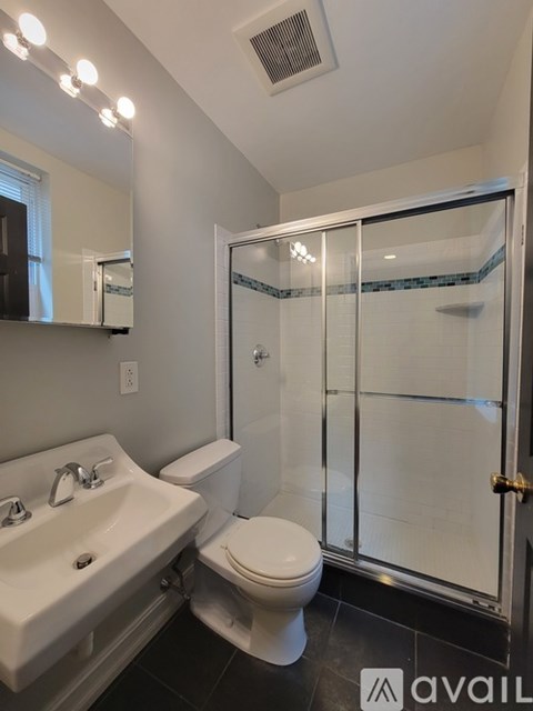 A bathroom with a toilet, sink, and shower.
