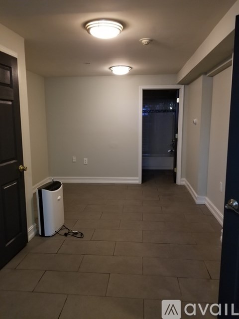 A room with a trash can and a door.