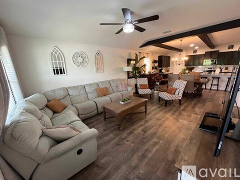 A living room with a white sofa and a ceiling fan.