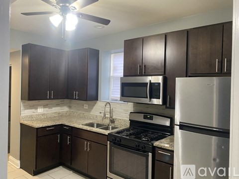 A kitchen with brown cabinets and stainless steel appliances.