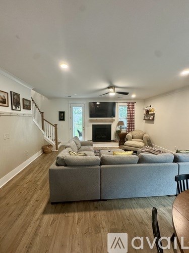 A living room with a grey couch and a wooden floor.