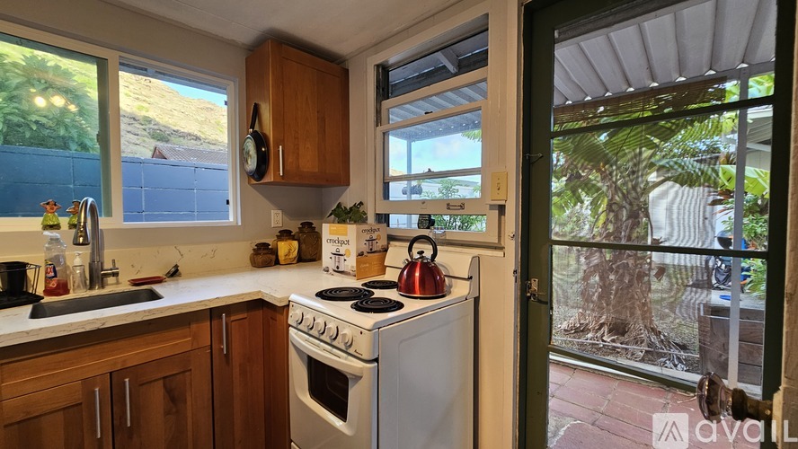 A kitchen with a white stove and wooden cabinets.