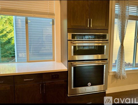 A modern kitchen with a stainless steel oven and wooden cabinets.