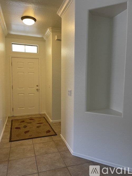 A hallway with a door and a rug on the floor.
