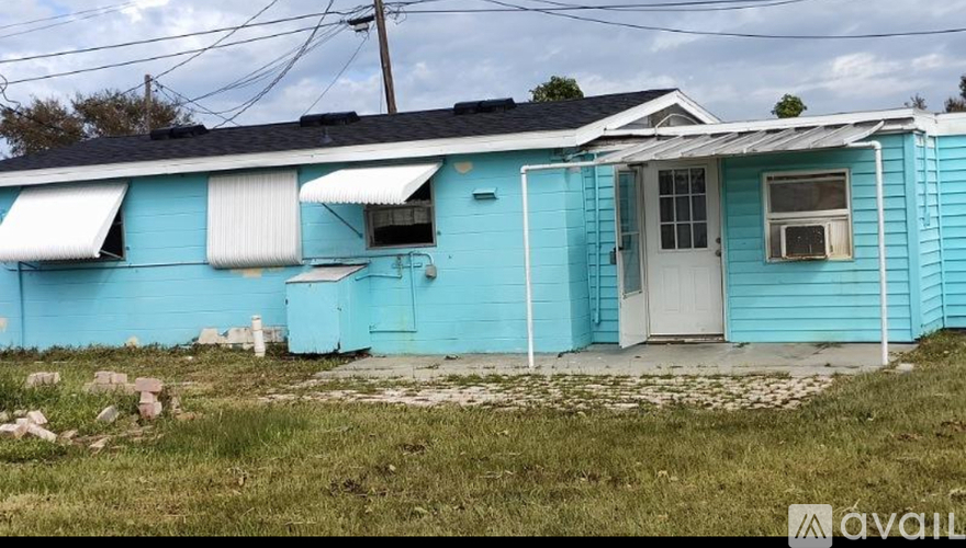 A blue house with a white door and windows.