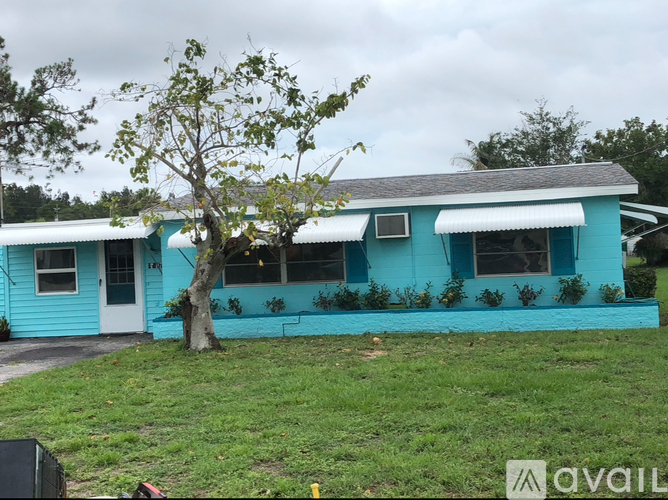 A blue house with a tree in front of it.