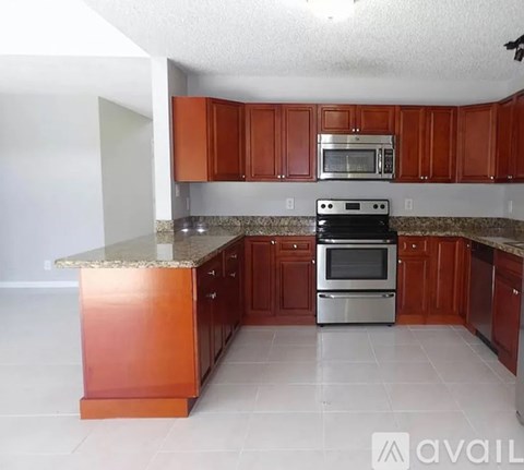 A kitchen with brown cabinets and a granite countertop.