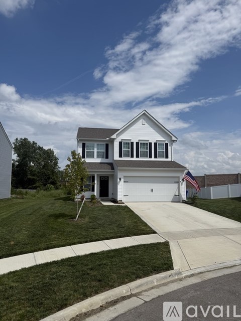 A two-story house with a garage and a driveway.