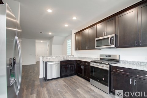 A kitchen with dark wood cabinets and stainless steel appliances.