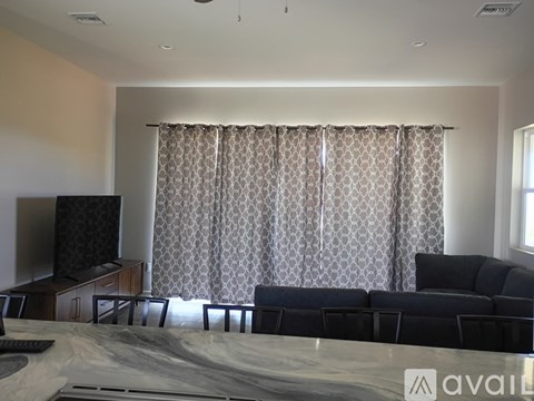 A living room with a black couch and a television.
