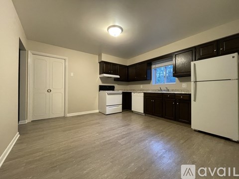 A kitchen with a white fridge, dishwasher and oven.