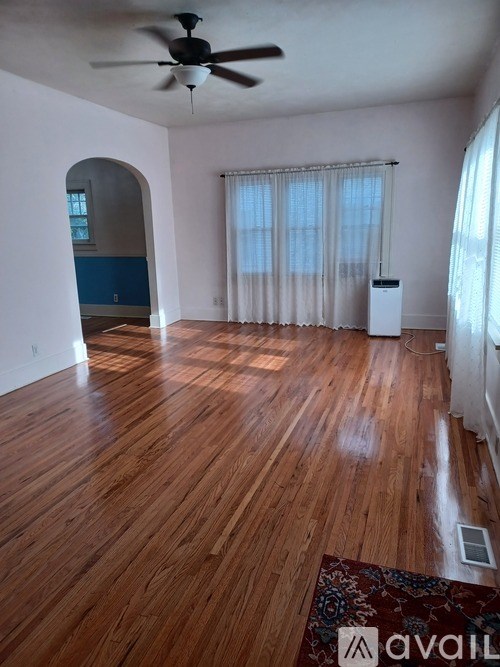 A room with wooden floors and a ceiling fan.