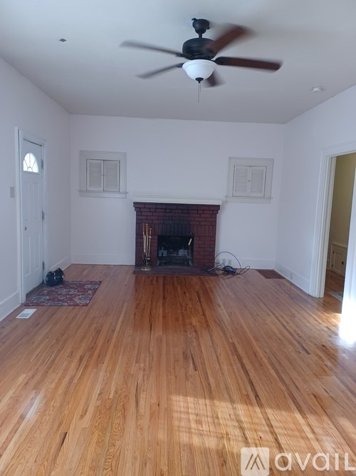 A room with a fireplace and a ceiling fan.