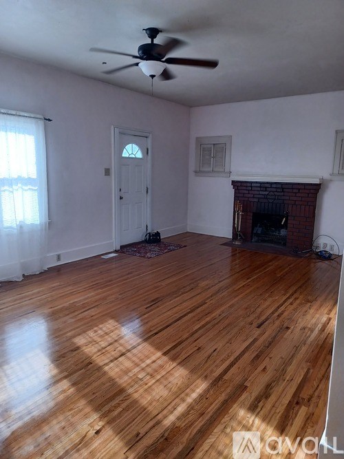 A room with a fireplace and a ceiling fan.