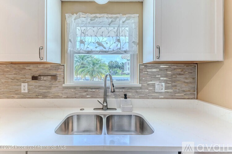 A modern kitchen with a double sink and a window.