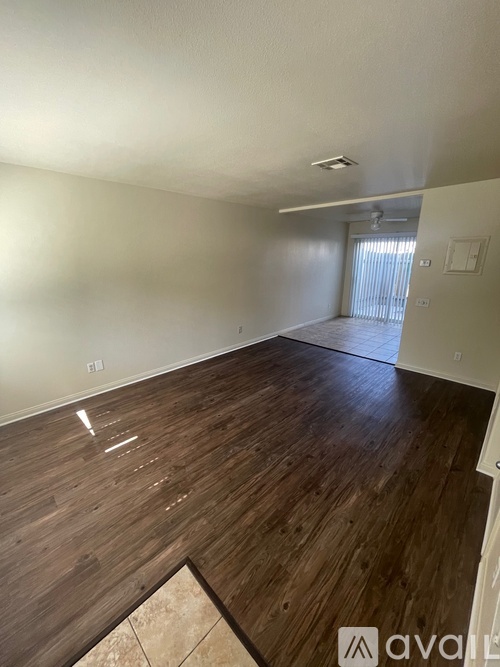 A room with wooden flooring and white walls.