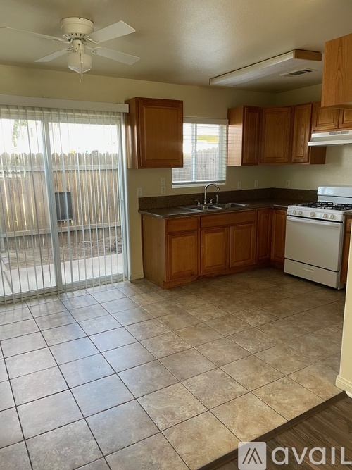 A kitchen with a white stove and wooden cabinets.