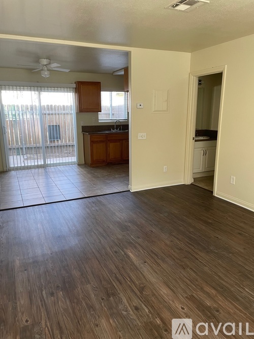 A room with wooden flooring and a ceiling fan.