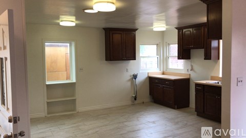 A kitchen with brown cabinets and a white door.