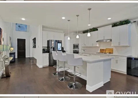 A modern kitchen with white cabinets and a central island.