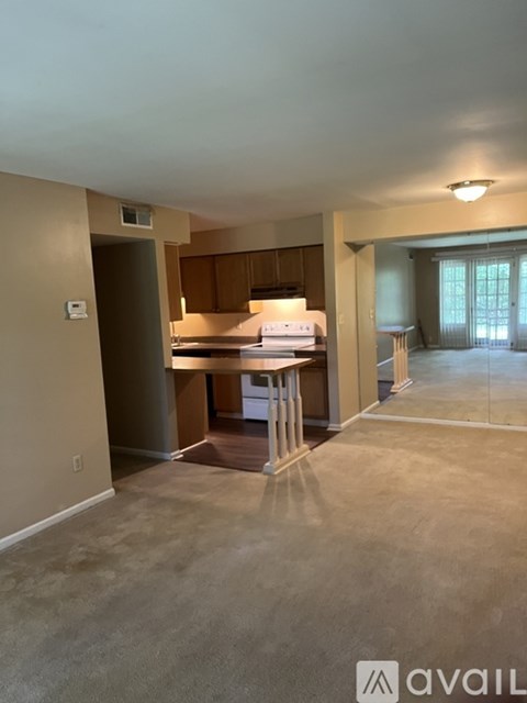 A room with a kitchenette and a dining table in a house.