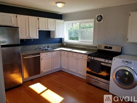 A kitchen with white cabinets and a stainless steel refrigerator.