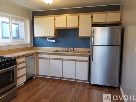 A kitchen with a stove, sink, and refrigerator.