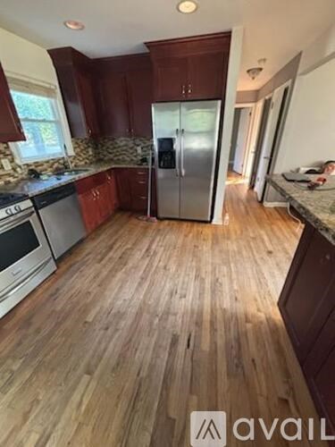 A kitchen with wooden floors and a refrigerator.