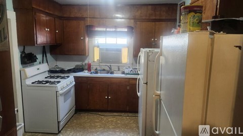 A kitchen with wooden cabinets and a white stove top oven.