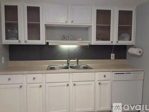 A kitchen with white cabinets and a washing machine.